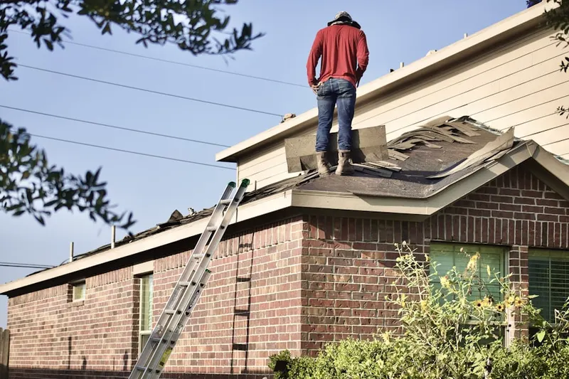 Professional roofer working on a residential roof in Finley